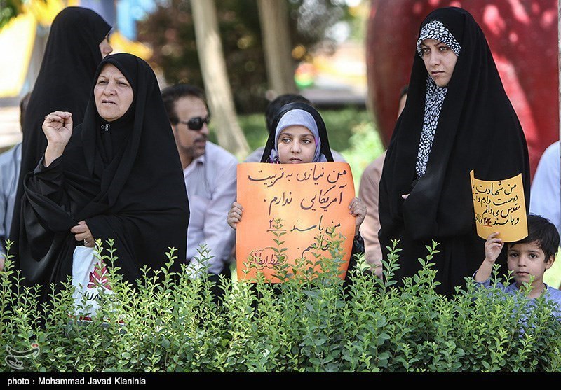 پلاکارد دست بچه‌ای که به نظر می‌رسه زیر۵ سال داشته باشه