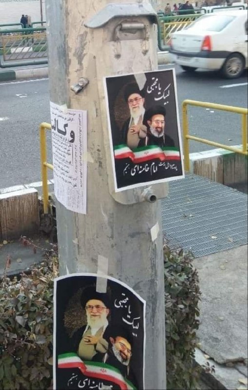 گفته شده؛ امروز، تهران، حوالی میدان انقلابتوزیع و نصب تراکت برای رهبری #مجتبی_خامنه‌ای beehnamنظرات اینجوری هم هست